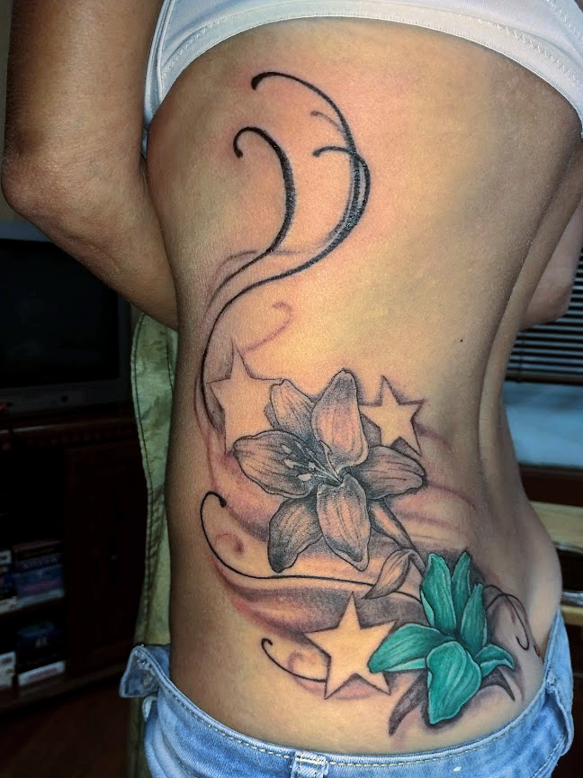 side tattoo with flowers and stars and swirls